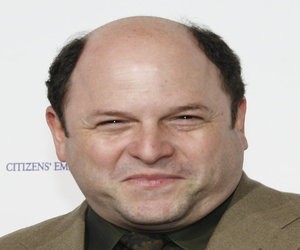 Jason Alexander smiling at camera with only hair on sides of head